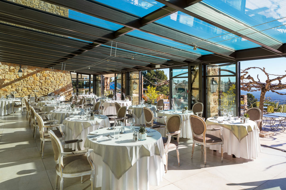 Table du restaurant de la Bastide de Tourtour avec une ouverture sur la terrasse extérieure