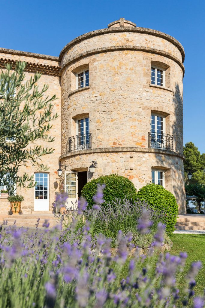 Close-up view with lavender in the foreground and a tower of the Bastide de Tourtour in the background