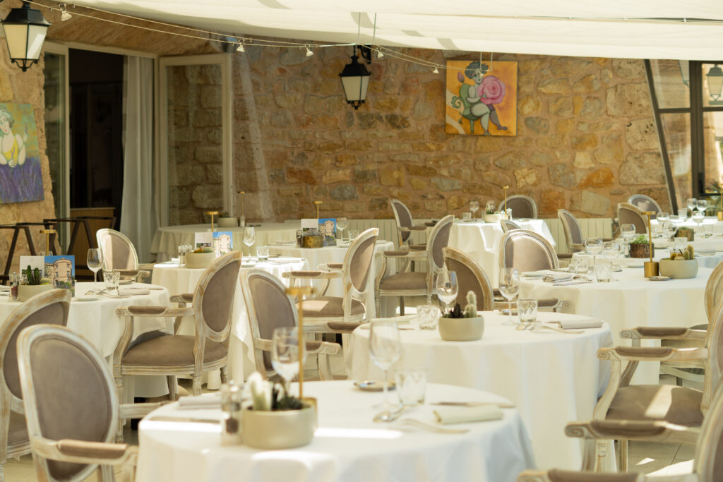Restaurant avec table dressé de blanc et chaises en tons beiges