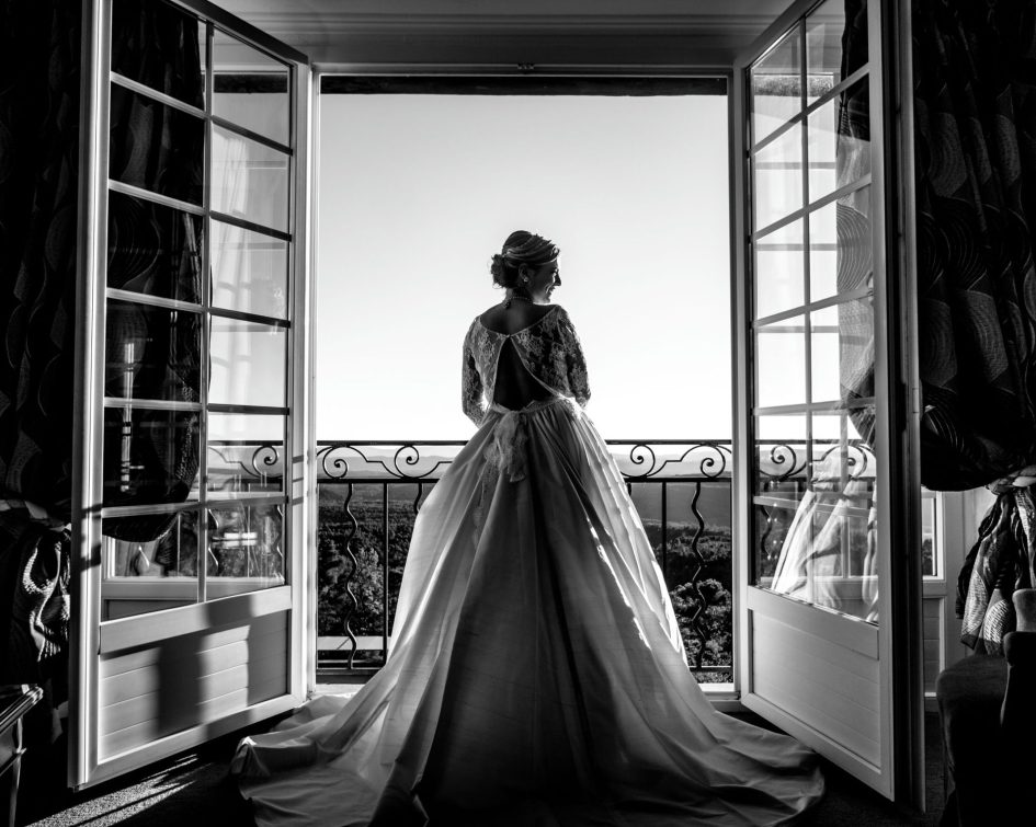 Photo - Réceptions privées 10 decembre 2018 118 sur 194 scaled Mariée en robe qui pose devant des portes vitrées ouvertes avec vue panoramique - Bastide de Tourtour