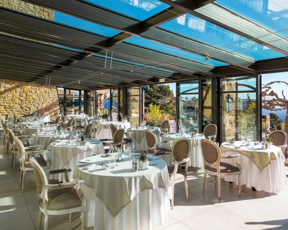 Table in the restaurant of the Bastide de Tourtour with an opening on the outside terrace