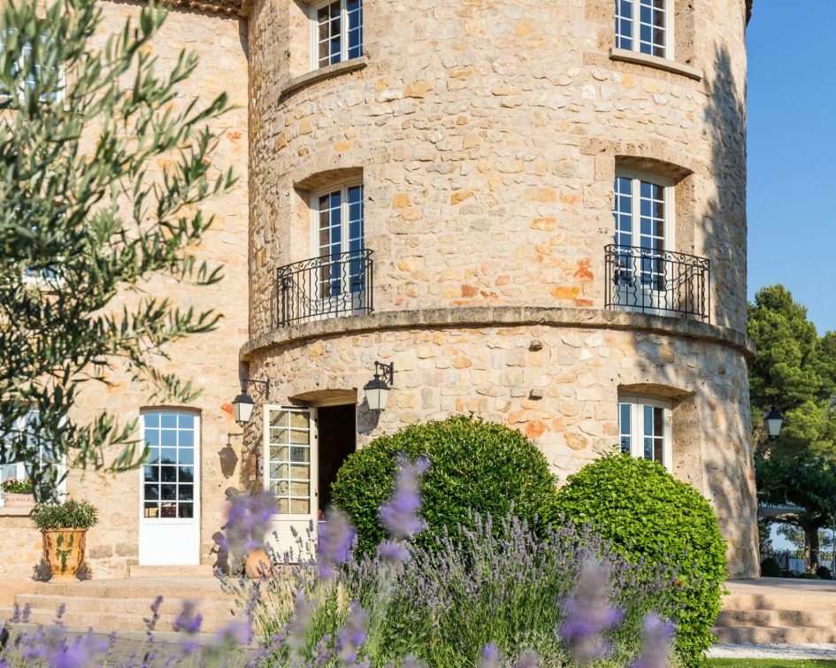Close-up view with lavender in the foreground and a tower of the Bastide de Tourtour in the background