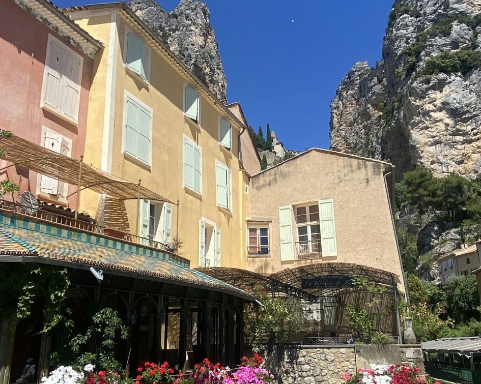 Bridge with decorative flowers next to a Provencal village house