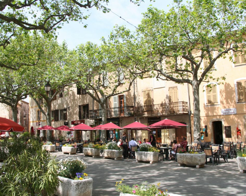 Place de village de Tourtour avec personnes en terrasse de restaurant