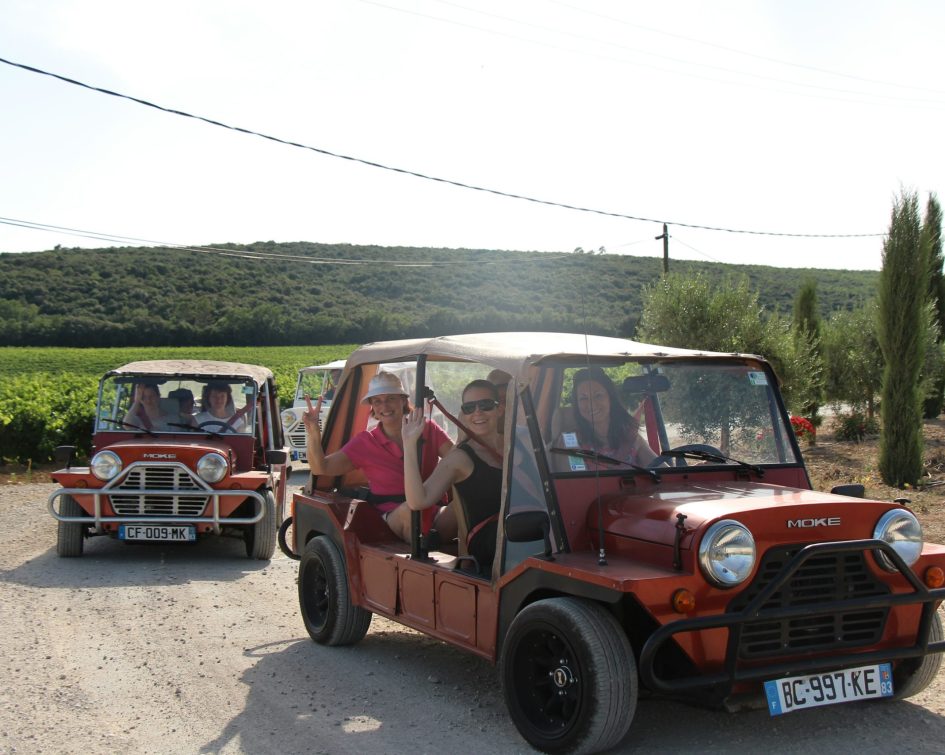 People smiling in a mini moke car at the Bastide de Tourtour